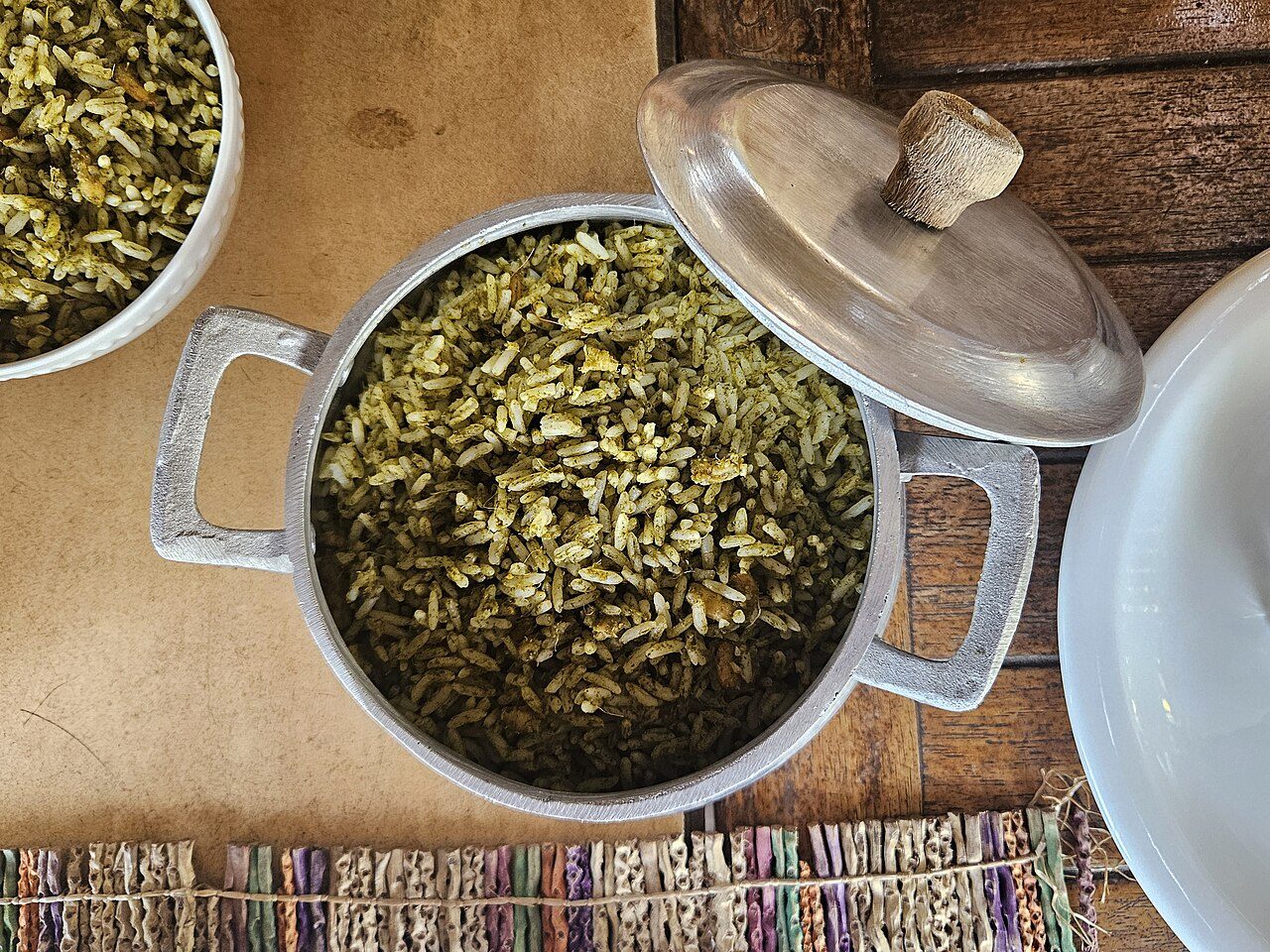 Arroz de cuxá esverdeado servido em panela de alumínio com tampa