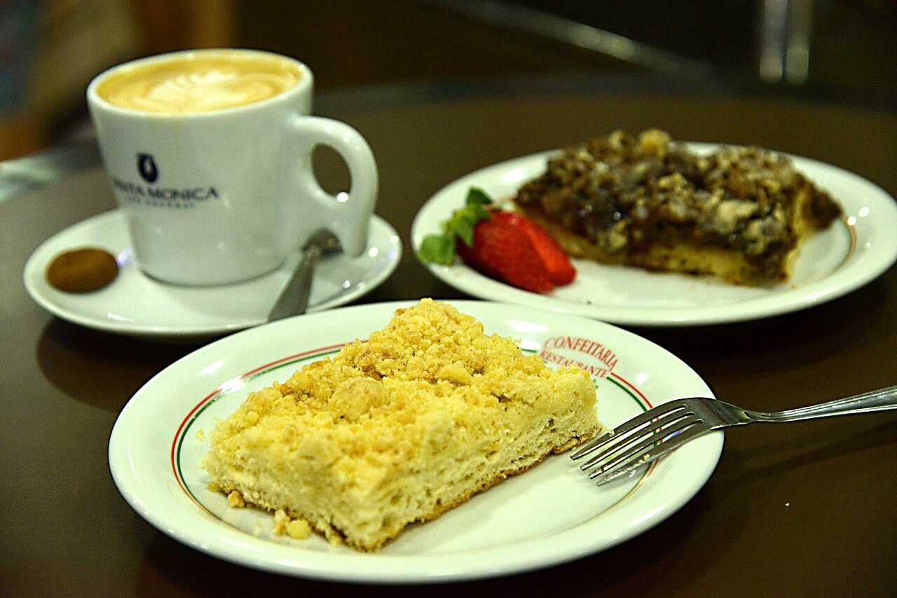 Pedaço de cuca de farofa servido com café em confeitaria de Pomerode, Santa Catarina