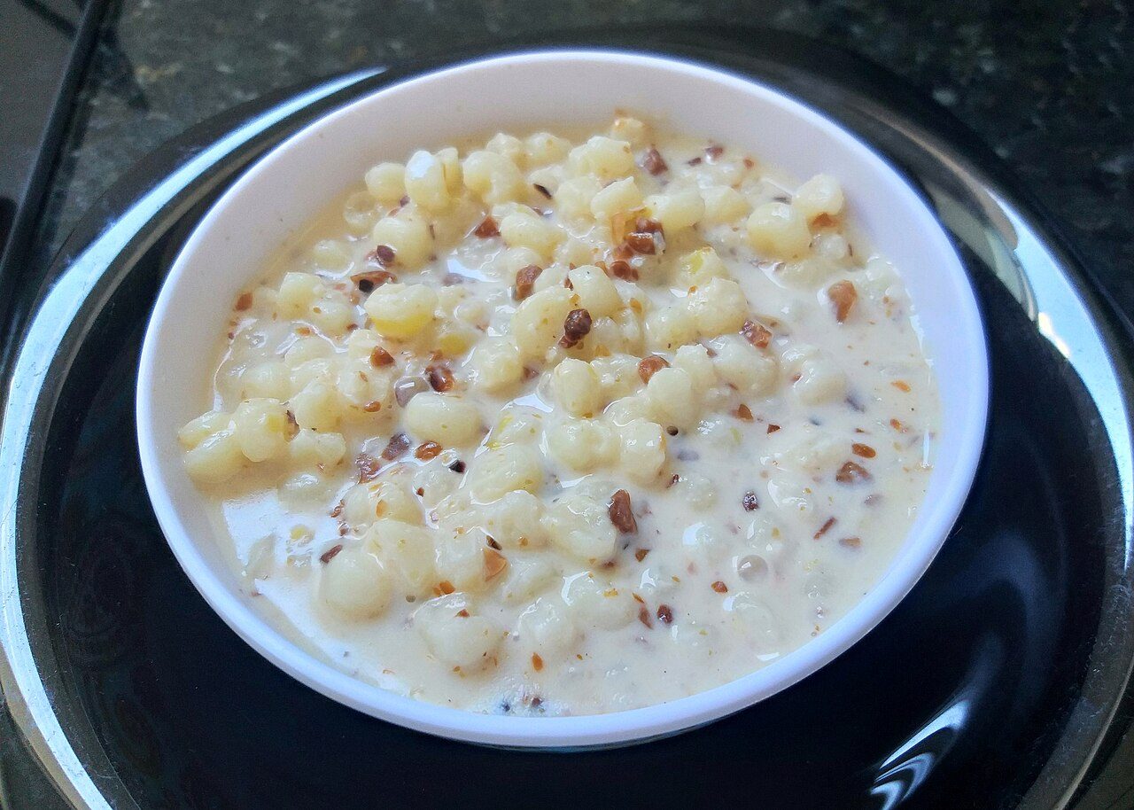 Tigela de canjica branca com amendoim e caldo cremoso de leite