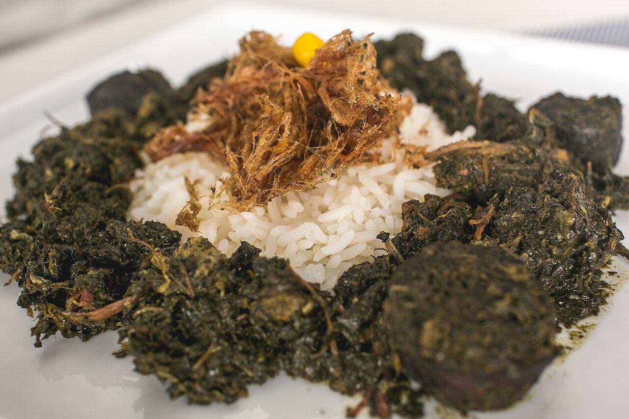 Prato de maniçoba paraense com arroz branco, carne desfiada e pimenta-de-cheiro