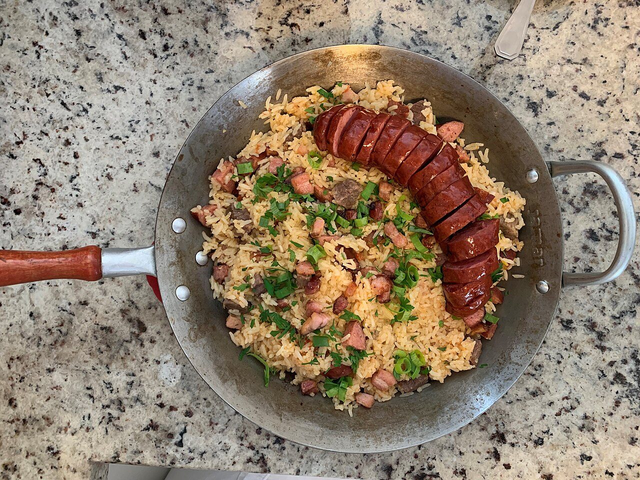 Arroz carreteiro com linguiça e cheiro-verde em frigideira de ferro