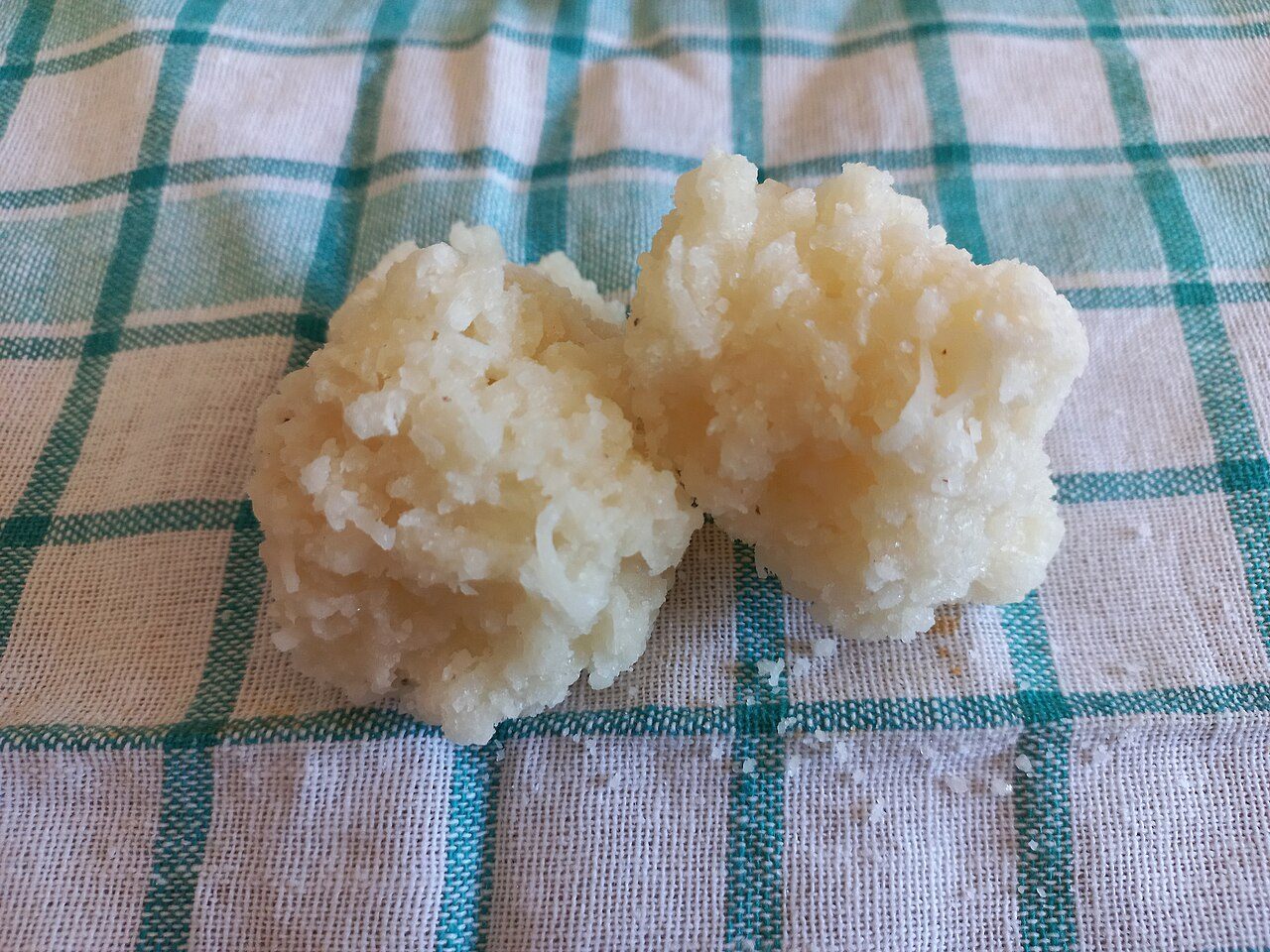 Duas cocadas brancas sobre pano de prato xadrez