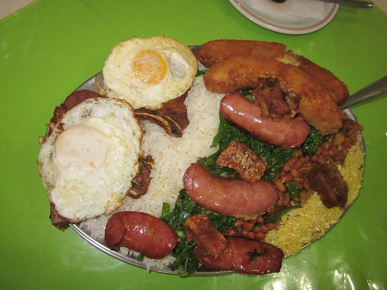 Prato de virado à paulista com ovos fritos, bisteca, linguiça, couve, torresmo, banana empanada, arroz e feijão